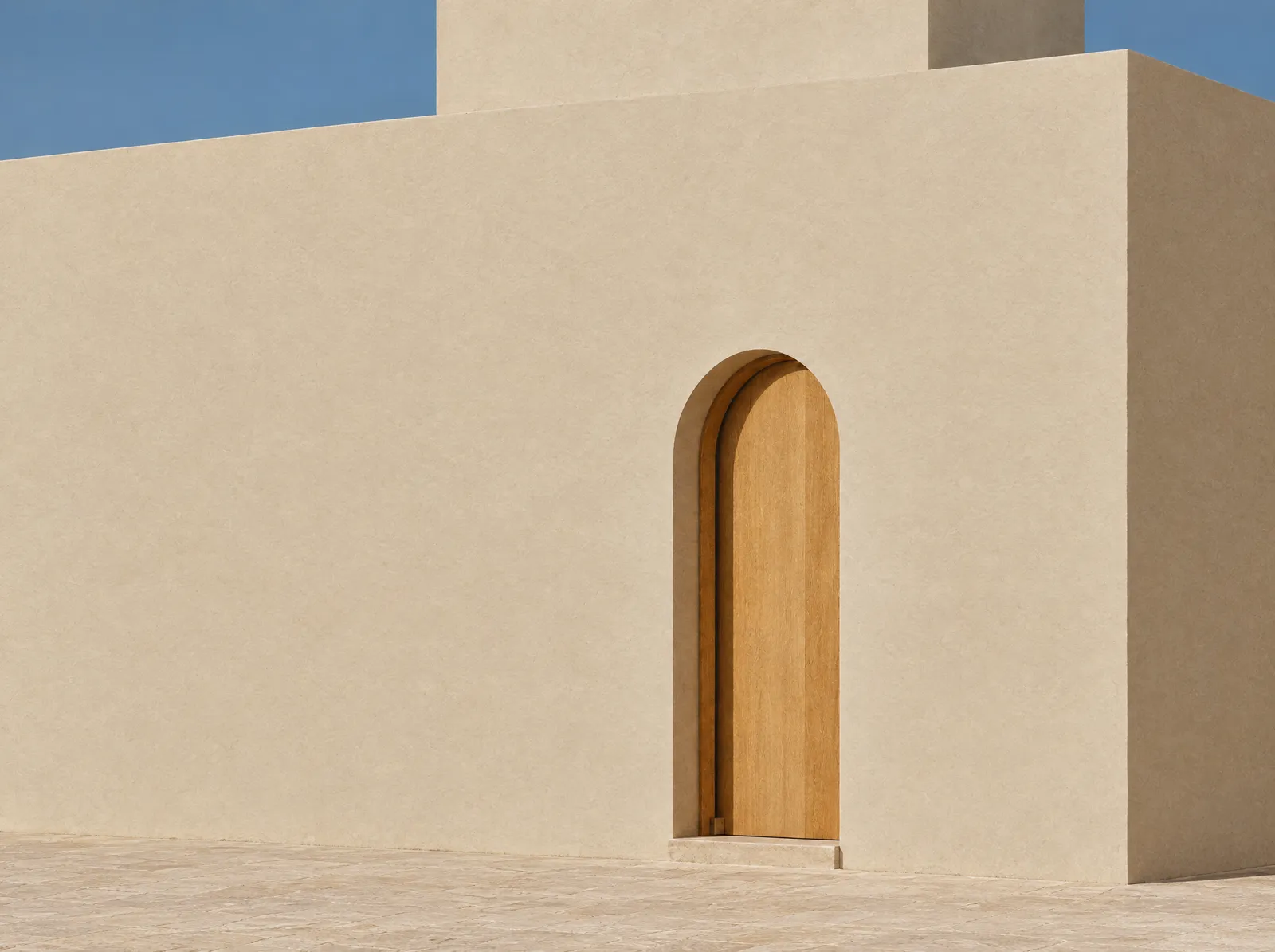 Limewashed wall with an arched oak door